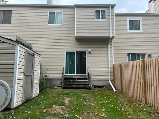a backyard of a house with barbeque and wooden fence