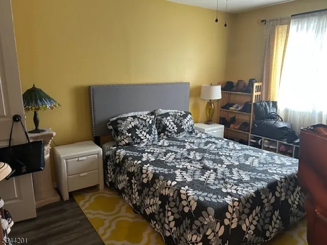 a bed sitting in a bedroom next to a window with wooden floor