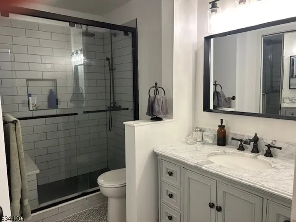 a bathroom with a granite countertop sink toilet and shower