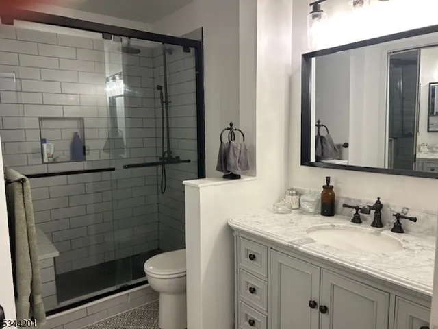 a bathroom with a granite countertop sink toilet and shower