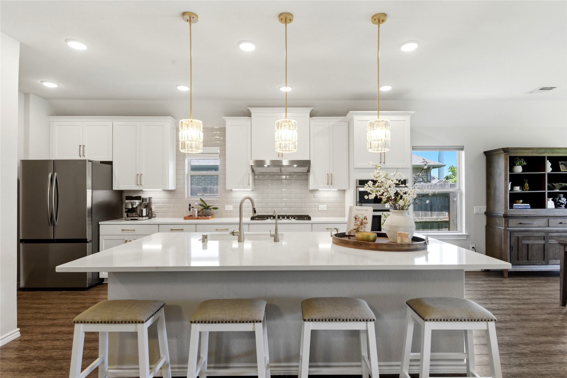 17834 Maple Ash Drive Spring, TX 77379 - Photo 12 of 50 Modern kitchen with a spacious island, elegant pendant lighting, and sleek stainless steel appliances. Features white cabinetry, a stylish backsplash, and ample natural light.