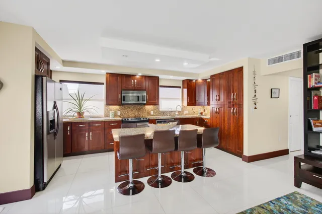 a kitchen with stainless steel appliances granite countertop wooden cabinets and a sink