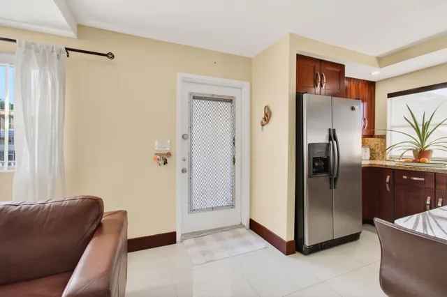 a living room with stainless steel appliances furniture and a window