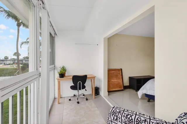 a bedroom with a bed couch and a large window