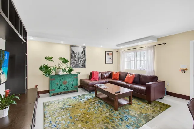 a living room with furniture and a potted plant