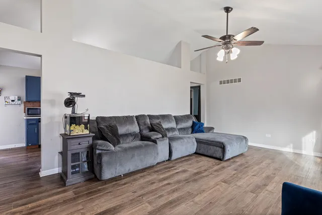 a living room with furniture and a wooden floor