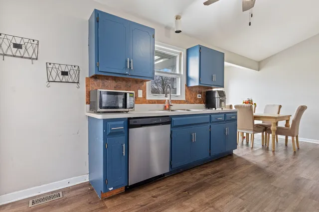a kitchen with granite countertop wooden floors and wooden cabinets