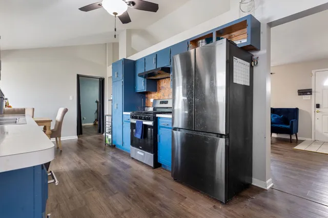a kitchen with stainless steel appliances a refrigerator and wooden floor