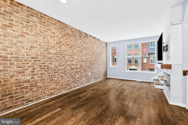 a view of empty room with wooden floor and fireplace