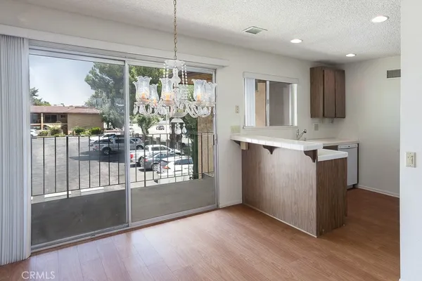 a view of kitchen with stainless steel appliances granite countertop cabinets and wooden floor