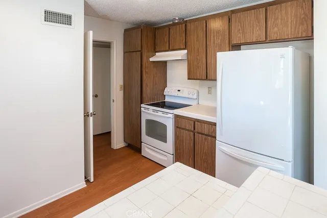 a kitchen with a white stove refrigerator and cabinets