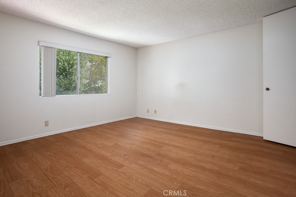 42849 15th Street West, Unit 4 Lancaster, CA 93534 - Photo 8 of 23 a view of an empty room with wooden floor and a window