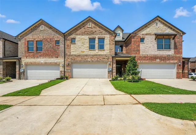a front view of a house with a yard and a garage