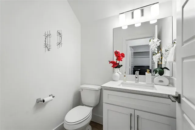 a bathroom with a sink vanity mirror and toilet