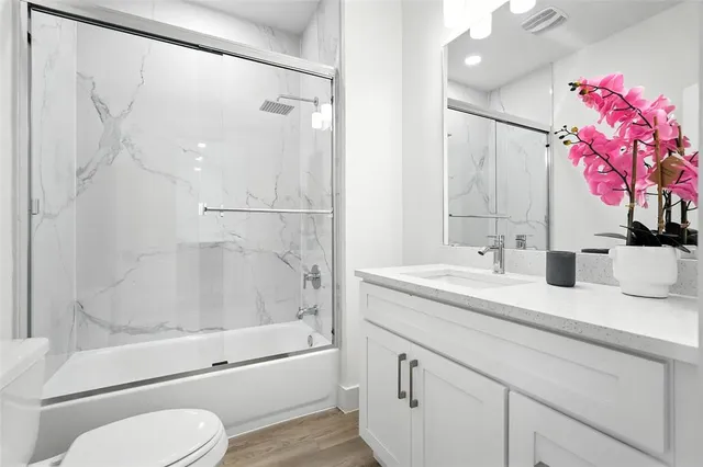 a bathroom with a granite countertop sink toilet and shower