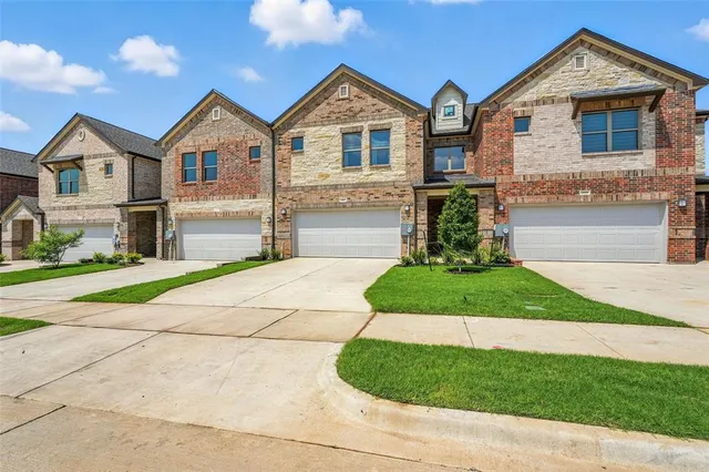 a front view of a house with a garden and yard