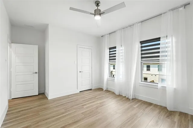 an empty room with cabinet and windows