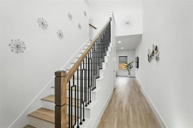 a view of a hallway with wooden floor and staircase