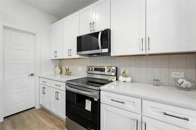 a kitchen with white cabinets and stainless steel appliances