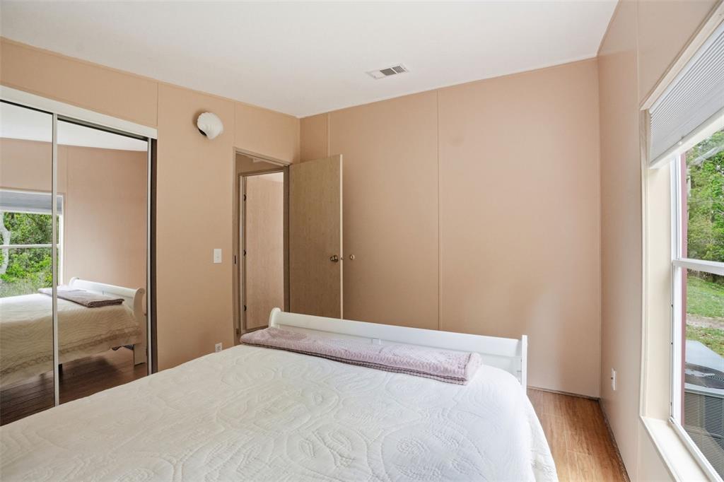 5161 Forest Glenn Drive Spring Hill, FL 34607 - Photo 29 of 51 a bedroom with a bed and large window with wooden floor