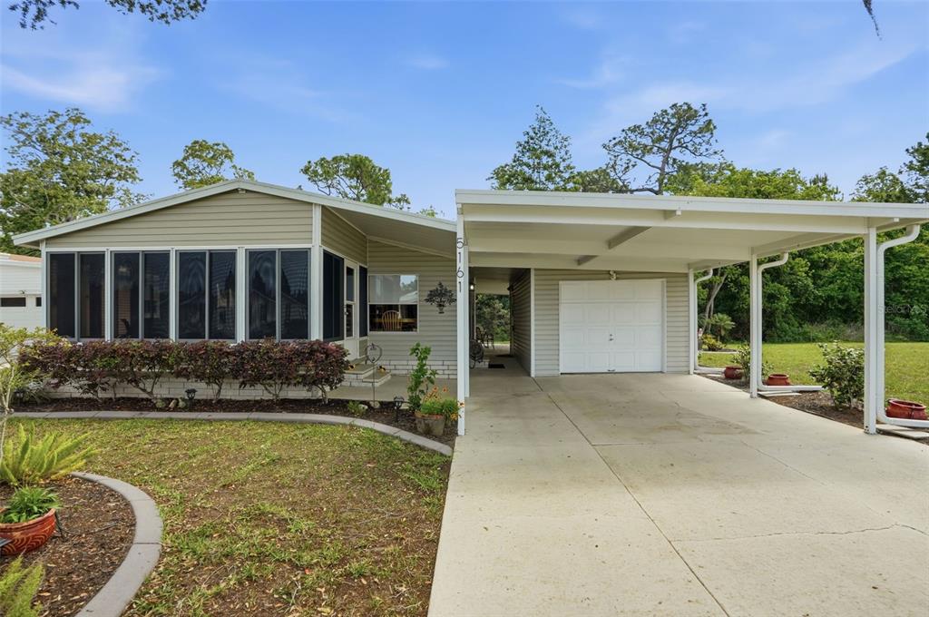 5161 Forest Glenn Drive Spring Hill, FL 34607 - Photo 3 of 51 front view of a house with a garden