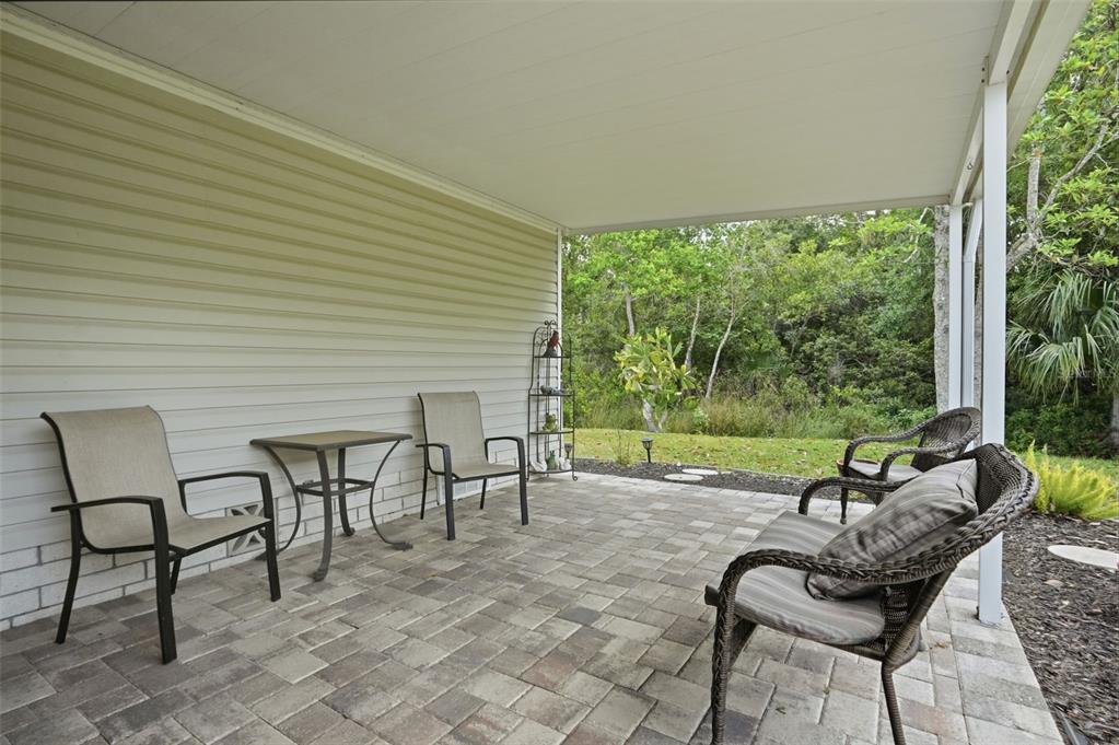 5161 Forest Glenn Drive Spring Hill, FL 34607 - Photo 36 of 51 a view of a patio with table and chairs and floor to ceiling window