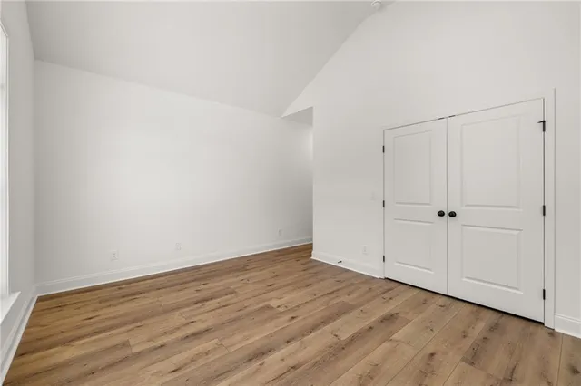 a view of empty room with wooden floor