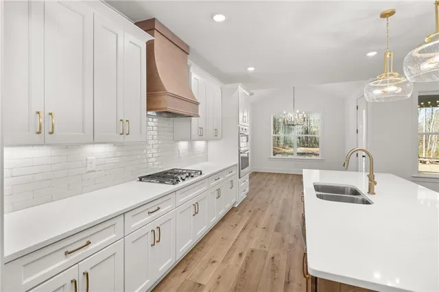 a kitchen with granite countertop a sink a stove refrigerator and cabinets