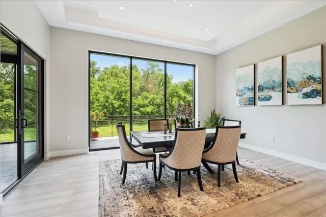 a view of a dining room with furniture large windows and wooden floor