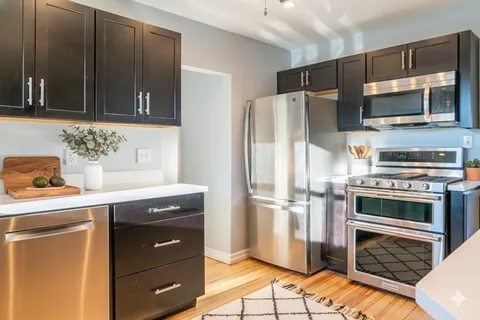 a kitchen with stainless steel appliances a stove a refrigerator and cabinets