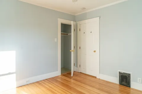 a view of an empty room with wooden floor