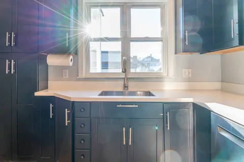 a sink with a window and cabinets