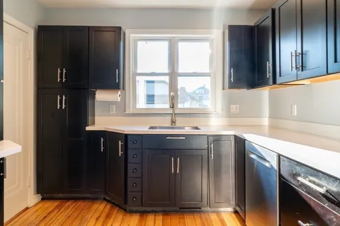 a kitchen with granite countertop a refrigerator and a sink
