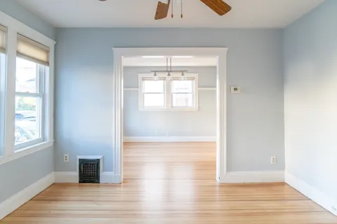 an empty room with wooden floor and windows