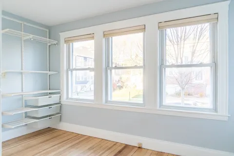 a view of a room with wooden floor and windows