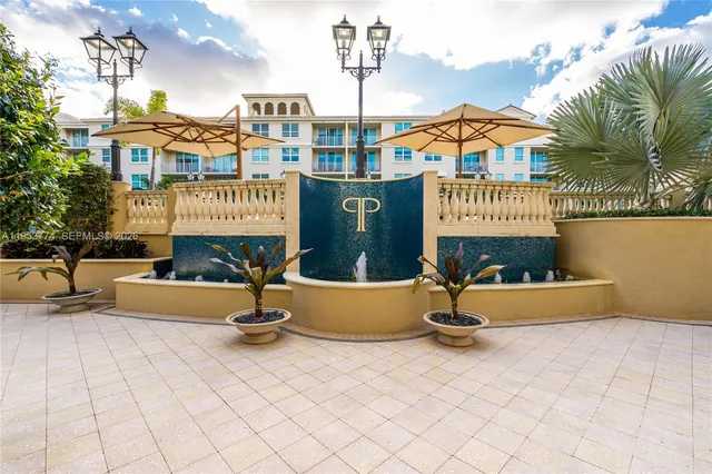 a front view of a building with glass door and seating space