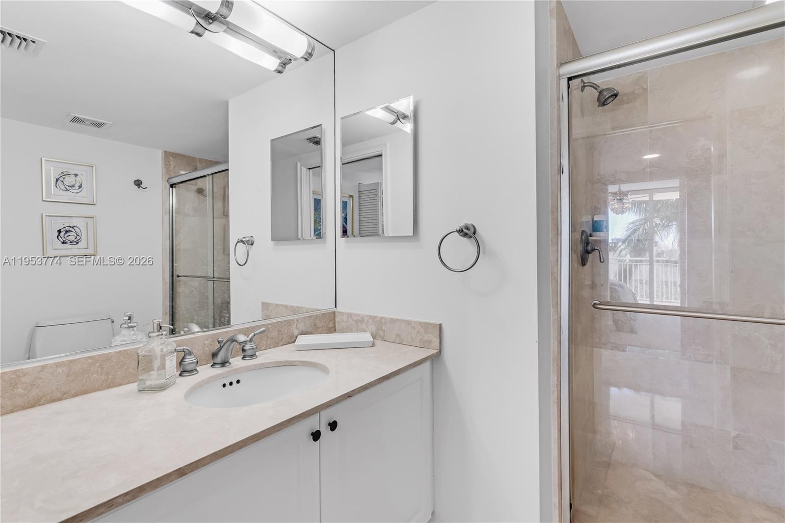 99 Southeast Mizner Boulevard, Unit 409 Boca Raton, FL 33432 - Photo 10 of 26 a bathroom with a double vanity sink mirror and shower