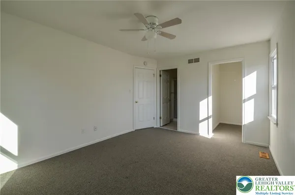 a view of a livingroom with a ceiling fan and window