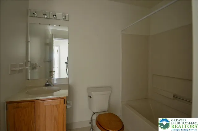 a bathroom with a granite countertop sink toilet and a mirror