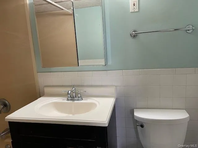 a bathroom with a sink a toilet and mirror
