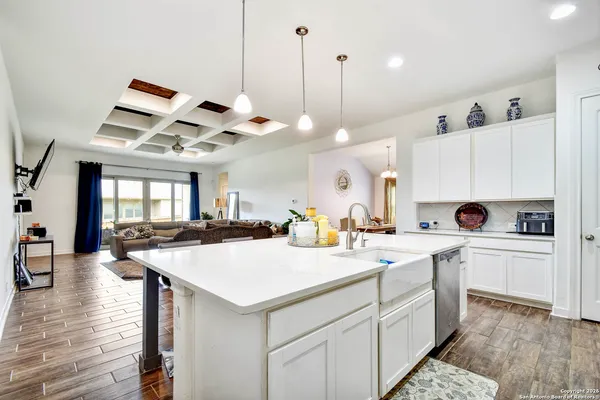 a kitchen that has a sink a stove and a wooden floor