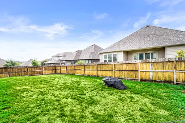 a backyard of a house with barbeque oven