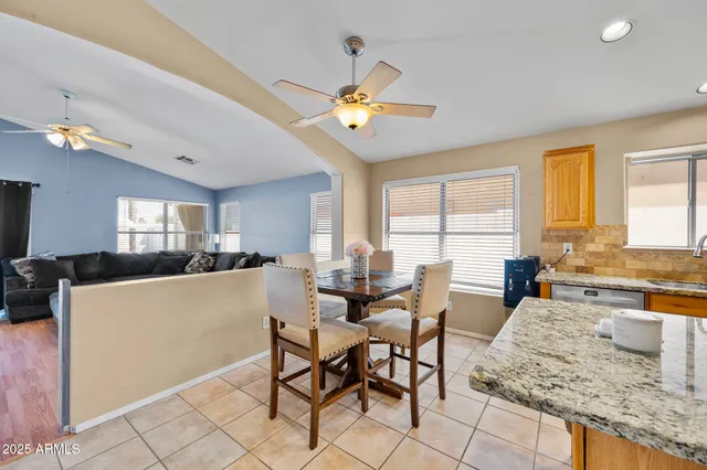 a kitchen with stainless steel appliances granite countertop a sink counter space cabinets and a view of living room