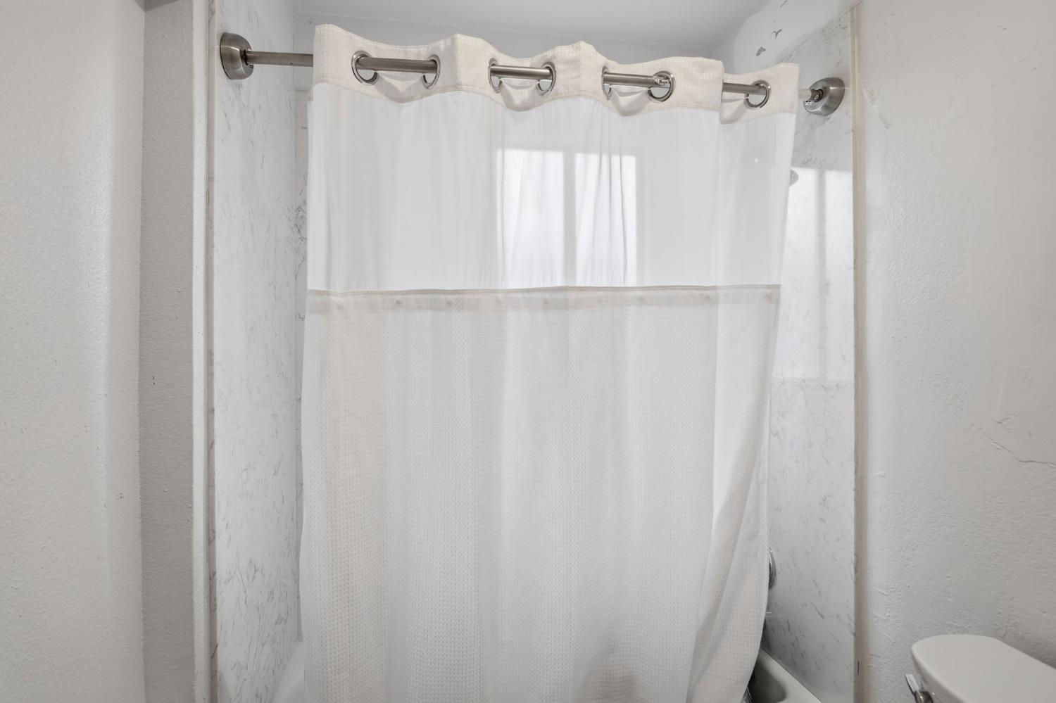 1740 Colorado Avenue Turlock, CA 95382 - Photo 23 of 37 a bathroom with a shower curtain