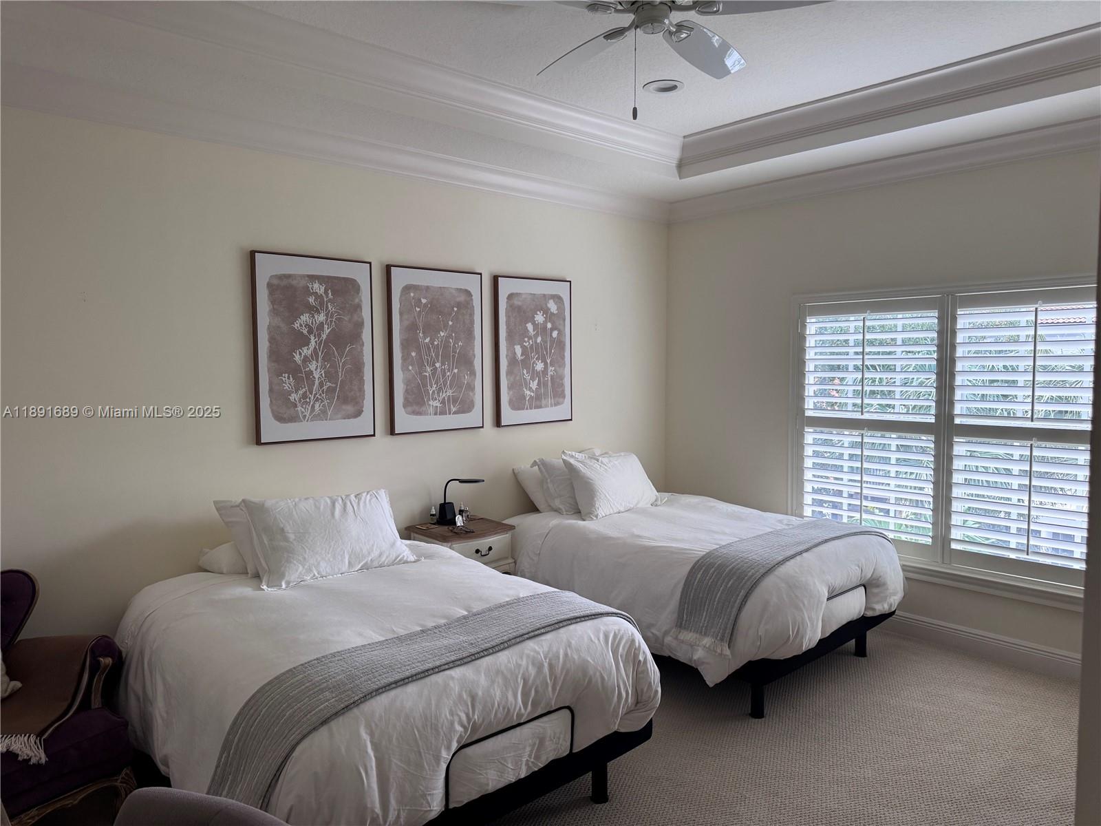 5565 Northeast Trieste Way Boca Raton, FL 33487 - Photo 19 of 30 a bedroom with two beds and a large window