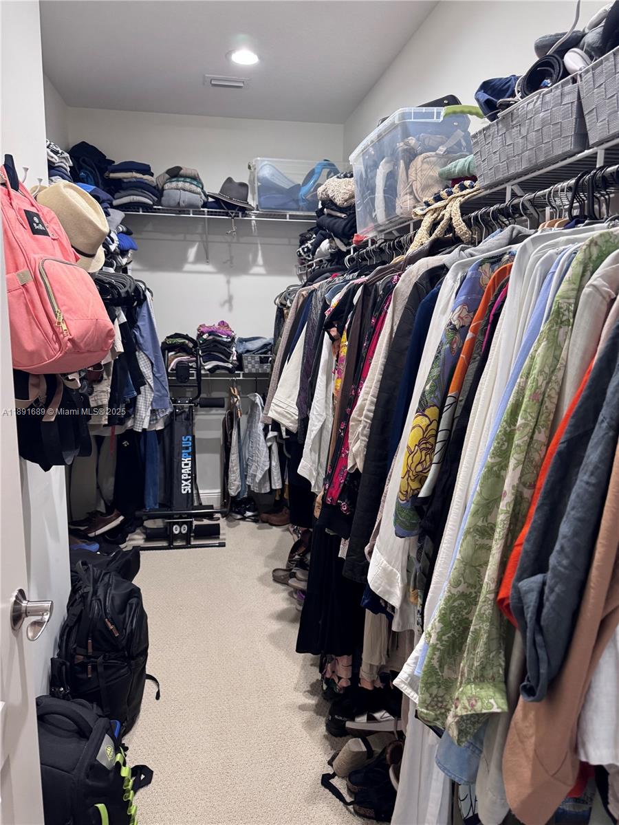 5565 Northeast Trieste Way Boca Raton, FL 33487 - Photo 20 of 30 a view of walk in closet with clothes and shoes