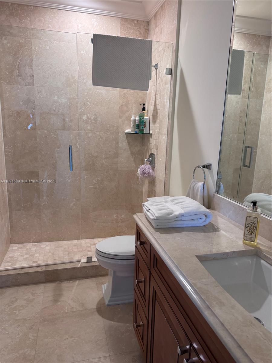 5565 Northeast Trieste Way Boca Raton, FL 33487 - Photo 23 of 30 a bathroom with a sink a toilet and shower