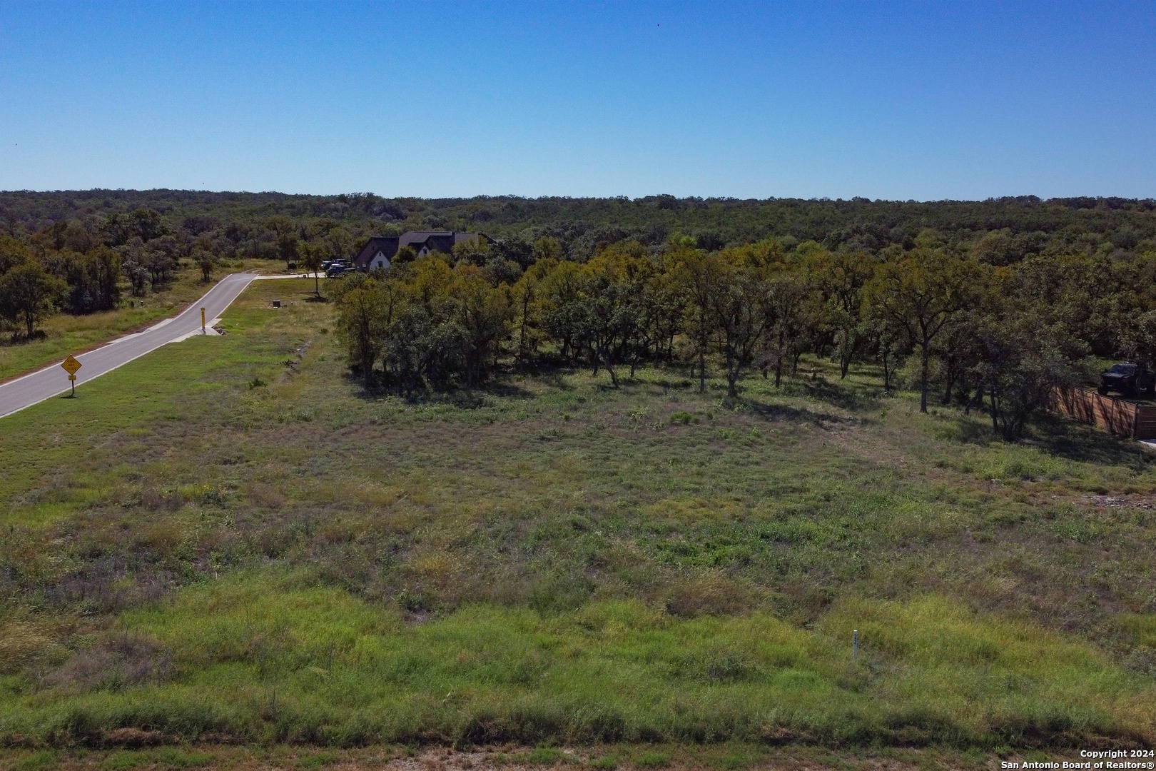 Lot 22 Stone Loop Castroville, TX 78009 - Photo 2 of 5 a view of a dry yard with trees in the background