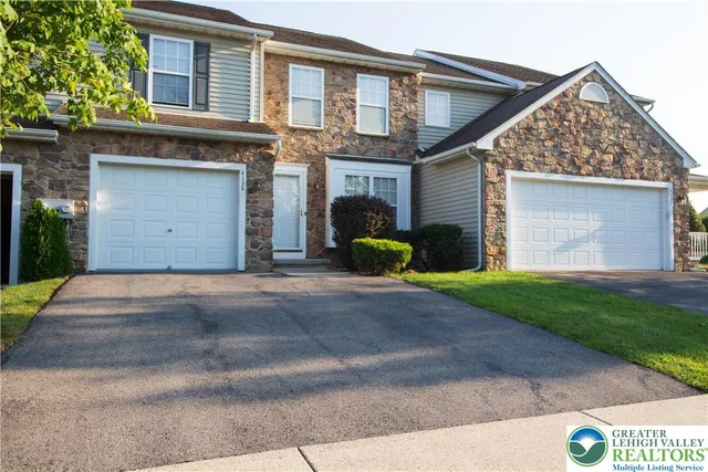 a view of a house with a yard and a large parking space