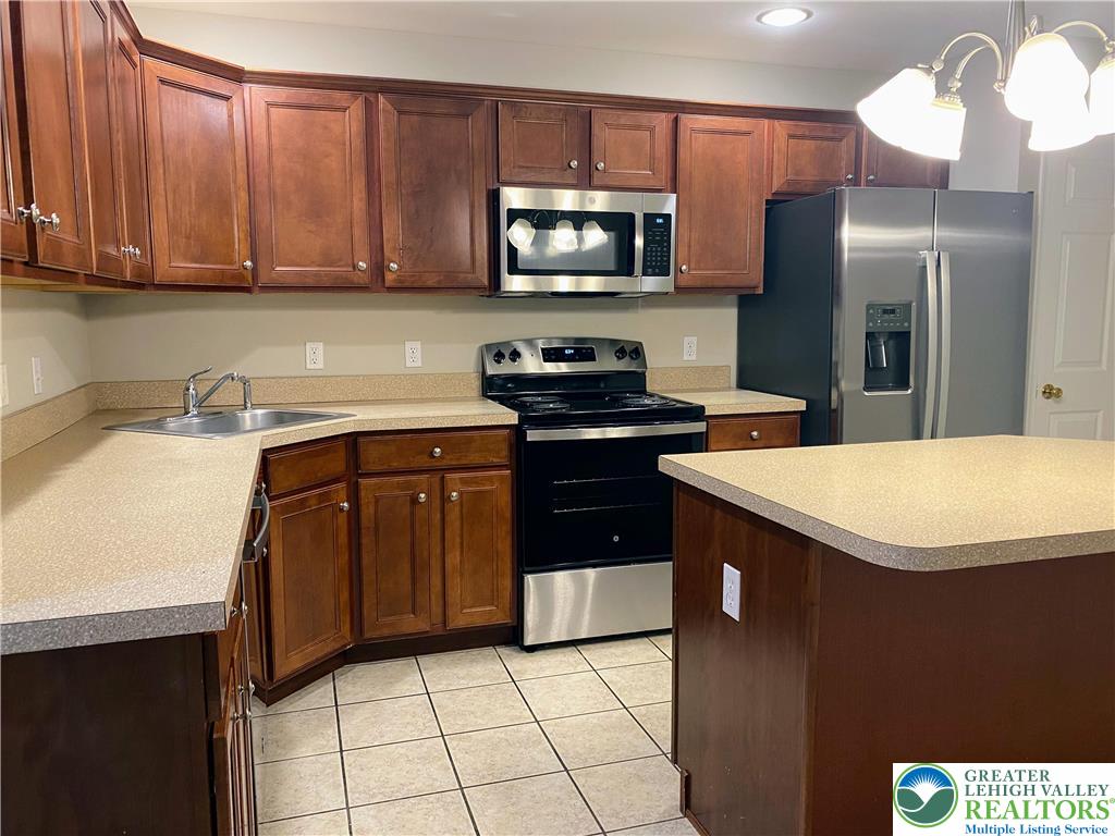 4138 Walter Road Bethlehem, PA 18020 - Photo 8 of 39 a kitchen with stainless steel appliances a sink a stove a microwave a sink a refrigerator and cabinets